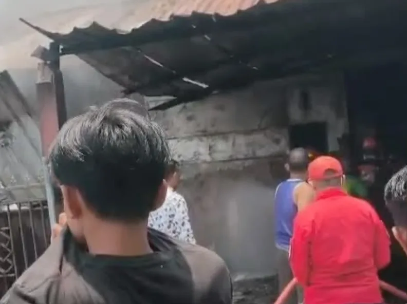 Petugas Damkarmat Kendari berupaya memadamkan api yang melalap tiga rumah di Puuwatu.